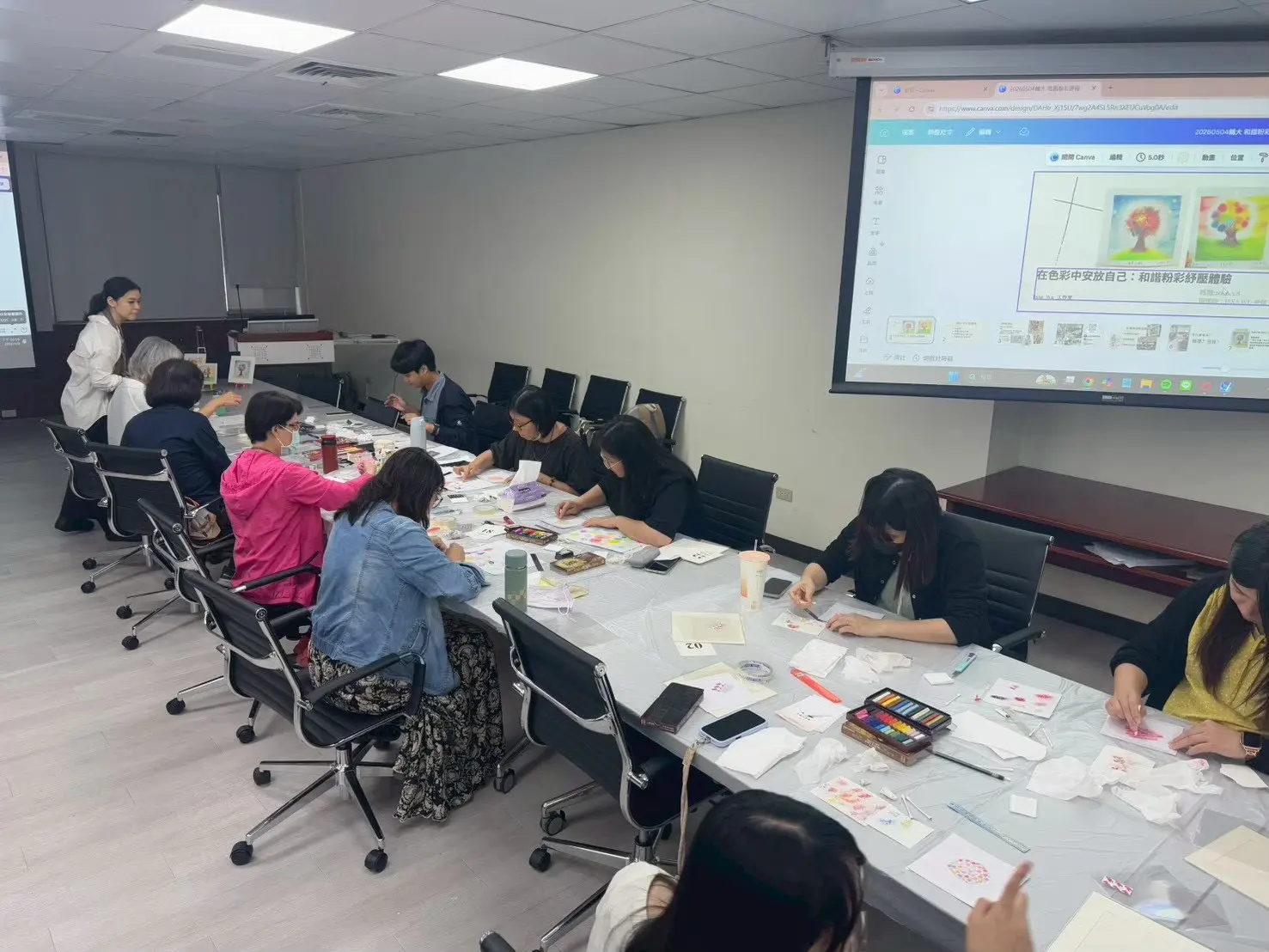 老師們圍坐在會議桌前完成和諧粉彩工作坊創作