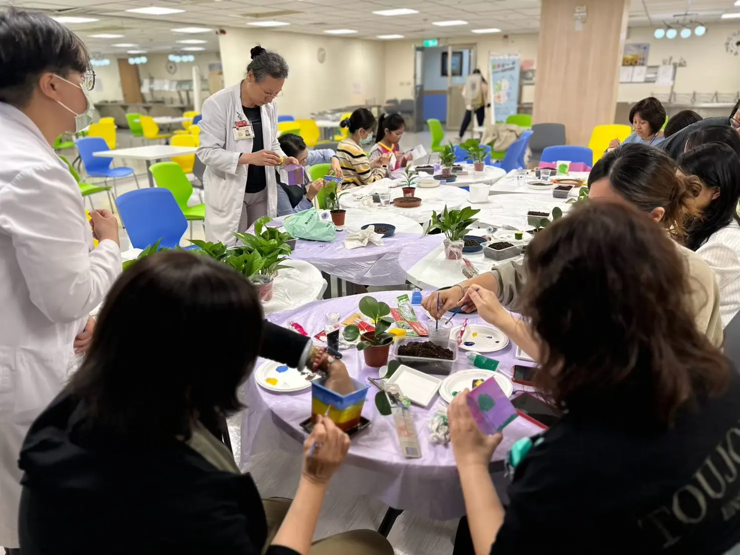 護理師在彩繪盆栽活動中用壓克力顏料彩繪盆器