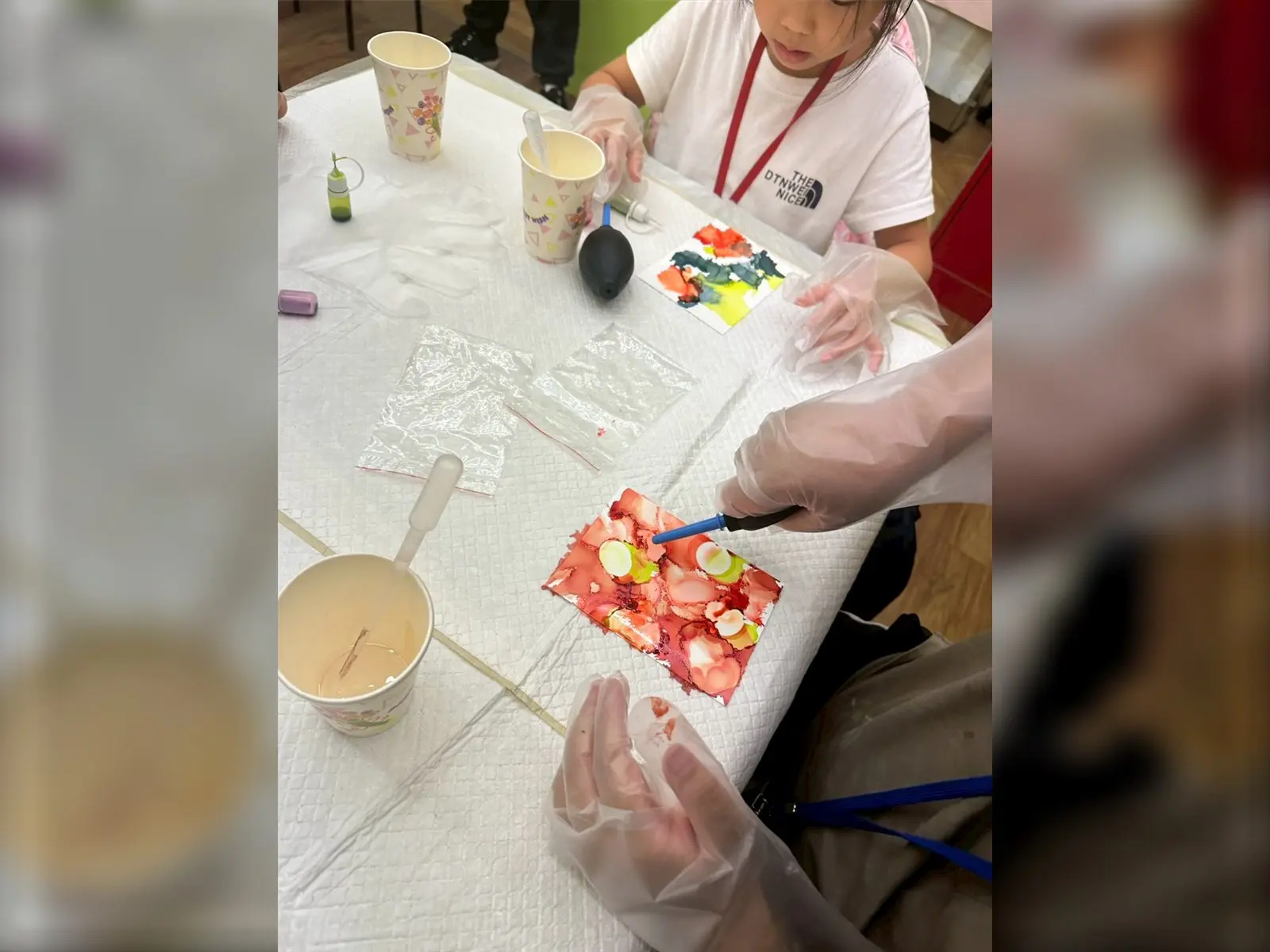 兒童暑期繪畫課程中，孩子戴手套用酒精墨水創作